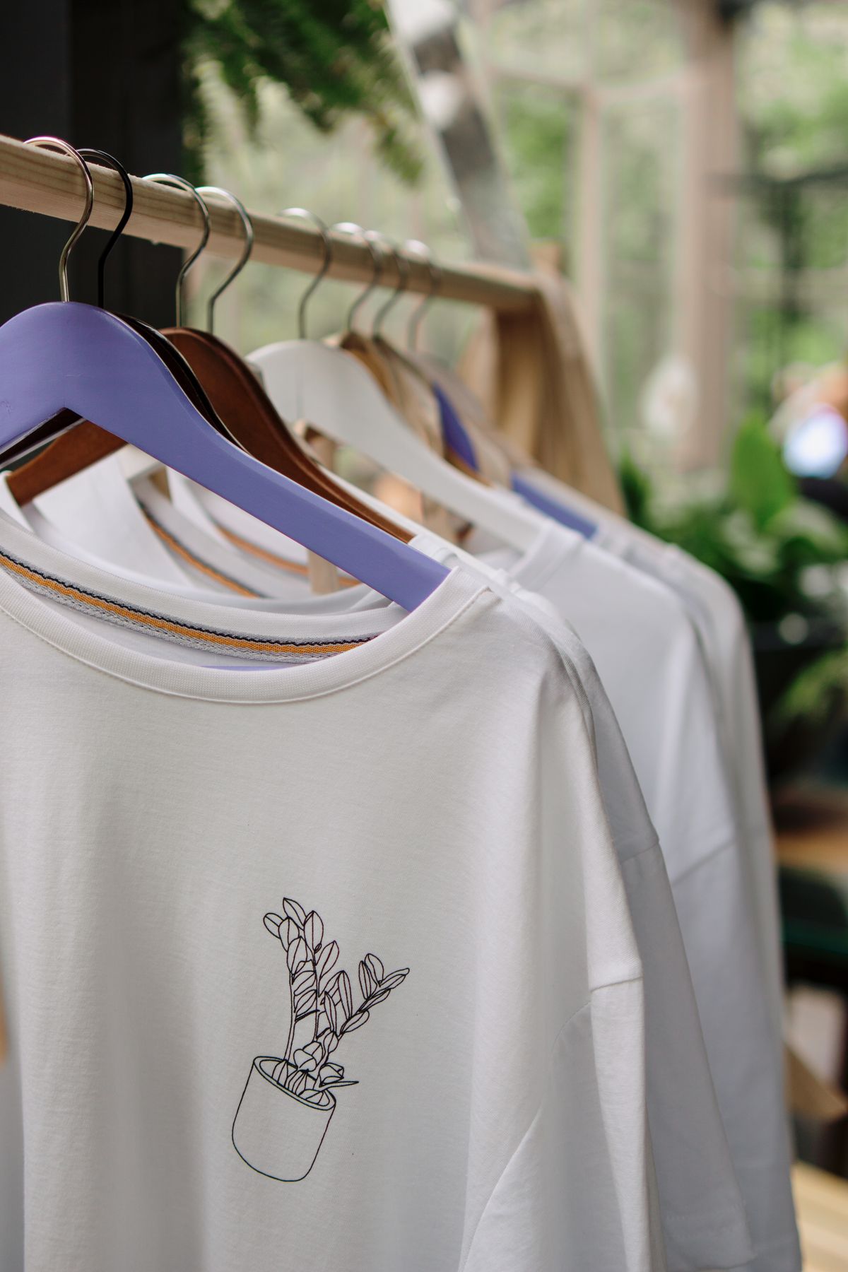 White printed t-shirts hanging on a wooden rack